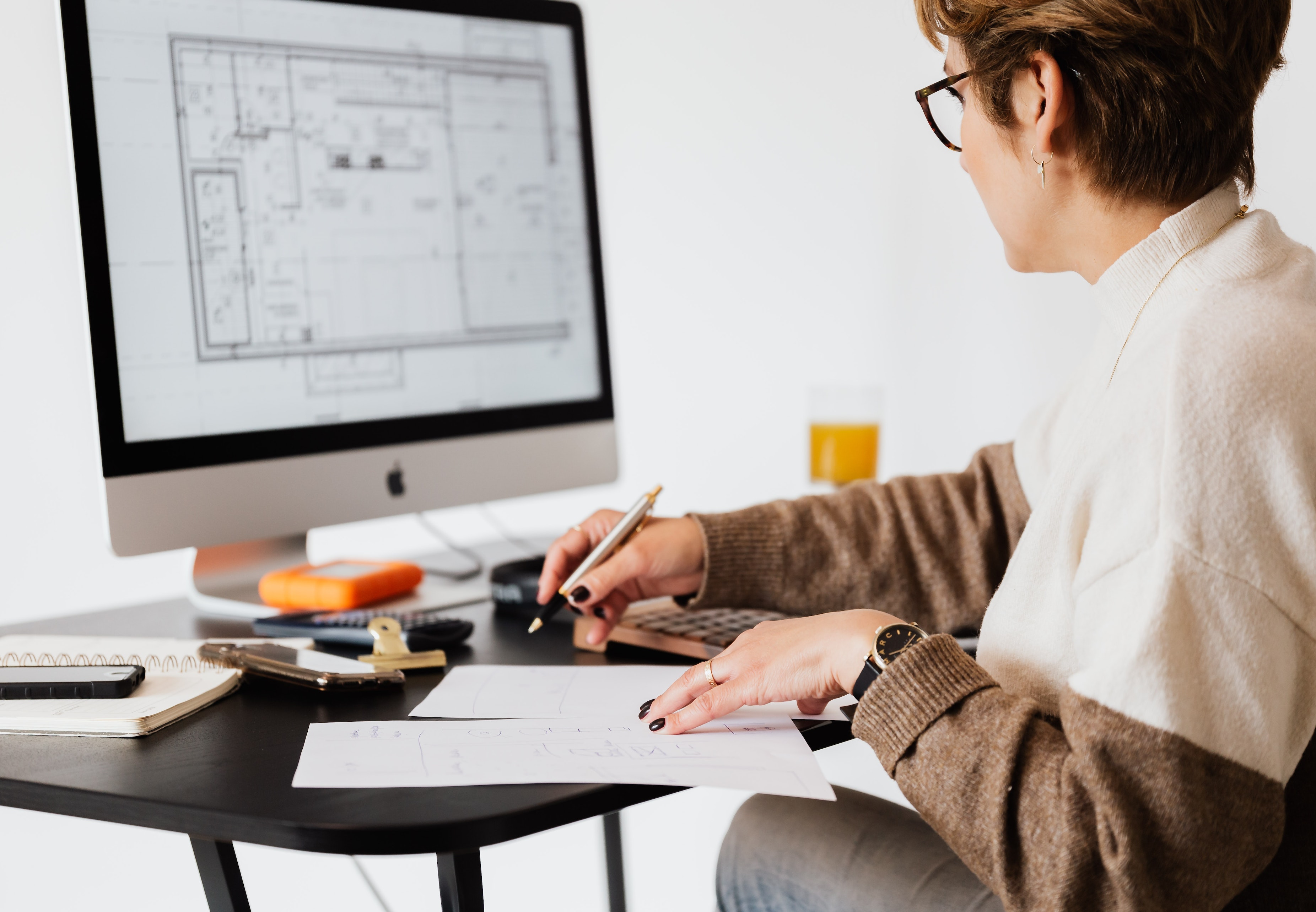 Picture a woman sitting in front of the computer analyzing a project schedule.