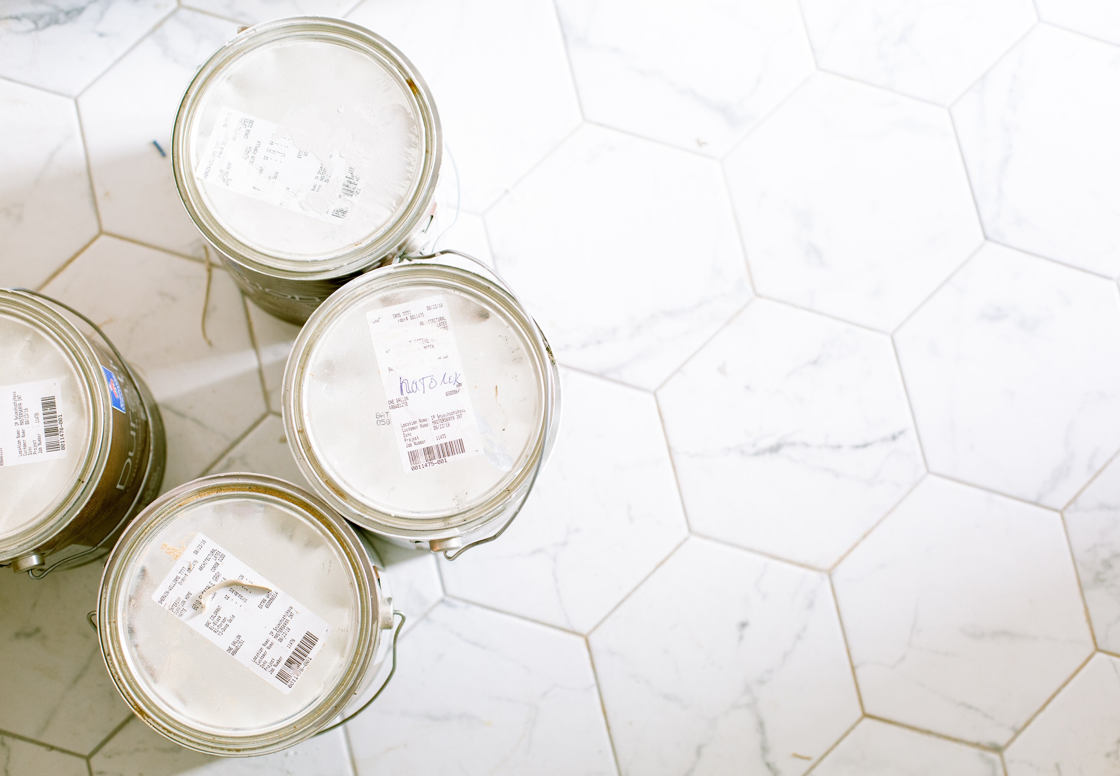 Picture of four cans of ink on the white floor.